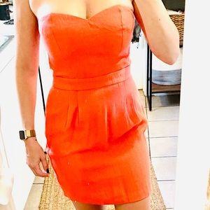 Salmon colored strapless dress.